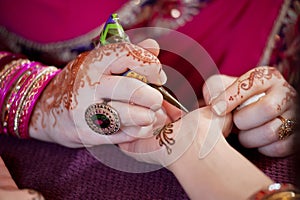 Artist Applying Henna to the Palm of a WomanÃ¢â¬â¢s Hand
